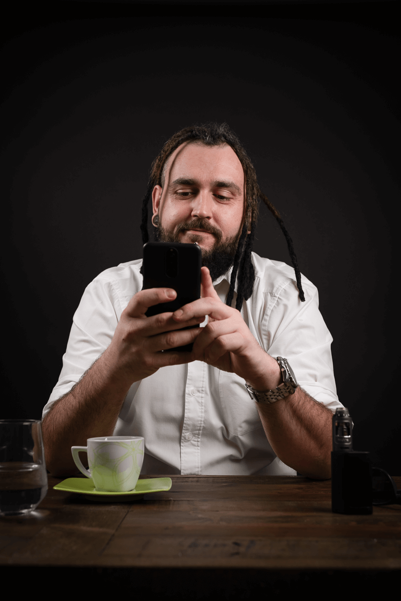 Mann sitzt bei Kaffee und liest Nachrichten
